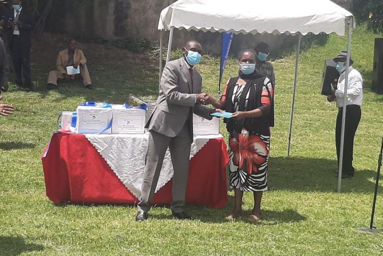 Prof. Jane Oduor, who participated in the establishment of Ogiek orthography, and Prof. Kithaka wa Mberia, a mother language activist, each receive a copy of the Gospel of St. Luke written in the Ogiek language.   