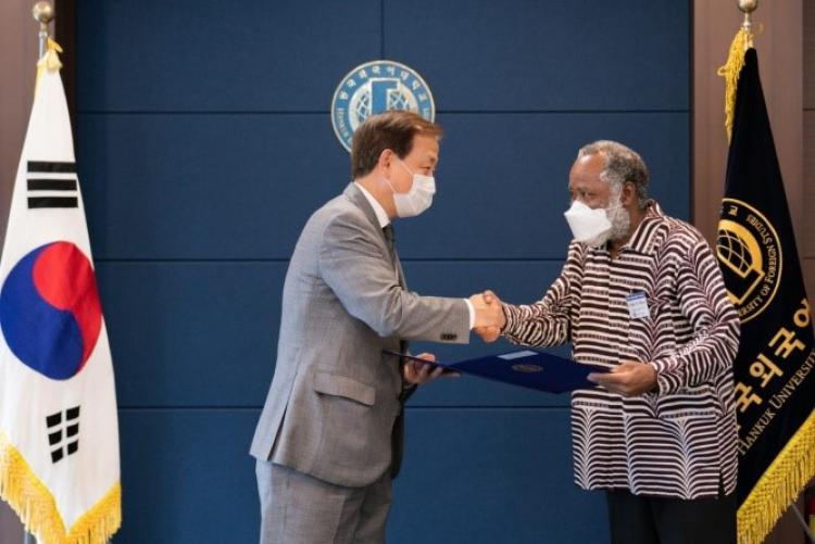 Prof. Kithaka wa Mberia receives a gift from the President of the Hankuk University of Foreign Studies (South Korea), In Chul Kim, after teaching in that University for two years.